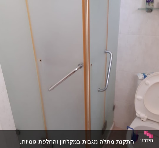 דלת זכוכית חלבית עם ידית מתכת במקלחת